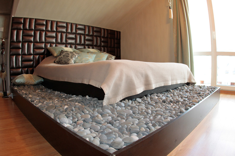 Кровать в спальной зоне мансарды